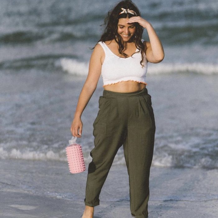 Woman on beach holding spiked brk water bottle