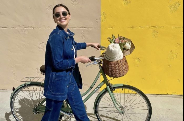 Woman walking linus bike with yellow background