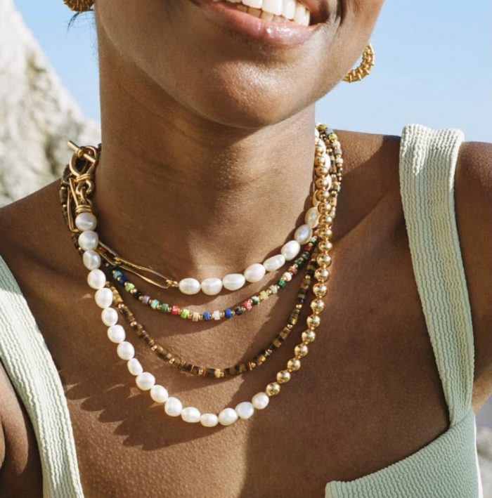 woman wearing missoma stacked necklaces