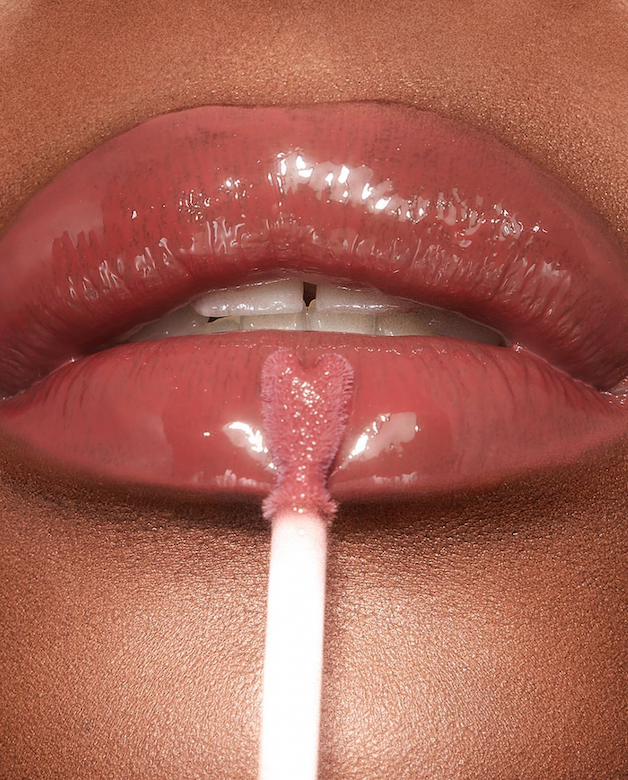 black woman's lips up close as she applies lip gloss