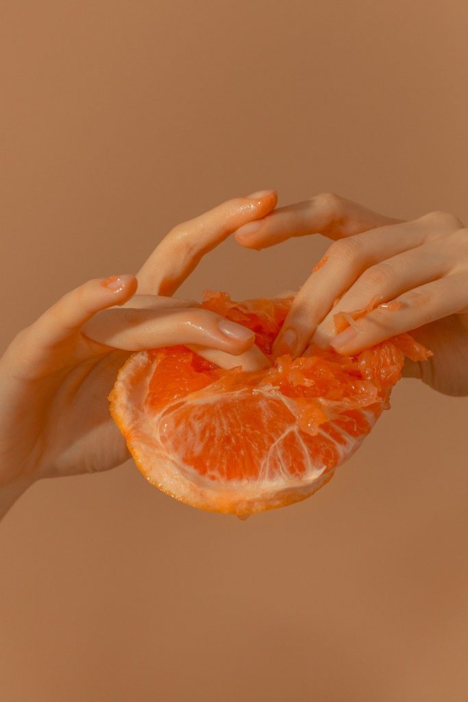 to hands gripping an orange 