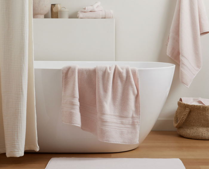 blush parachute towels draped over standalone tub